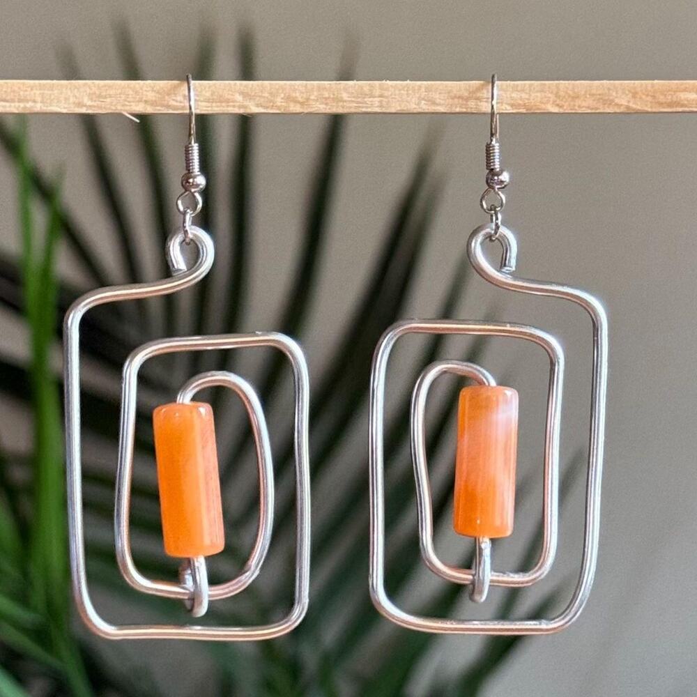 handmade silver wire spiral earrings with tangerine orange tube beads.